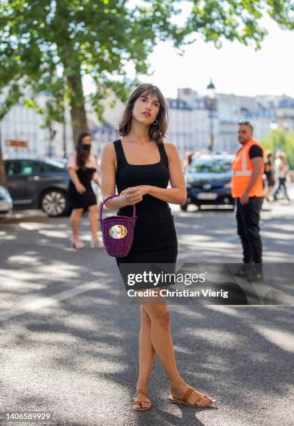 Jeanne Damas seen wearing black dress, purple straw bag outside Patou during Paris Fashion Week on July 03, 2022 in Paris, France.
