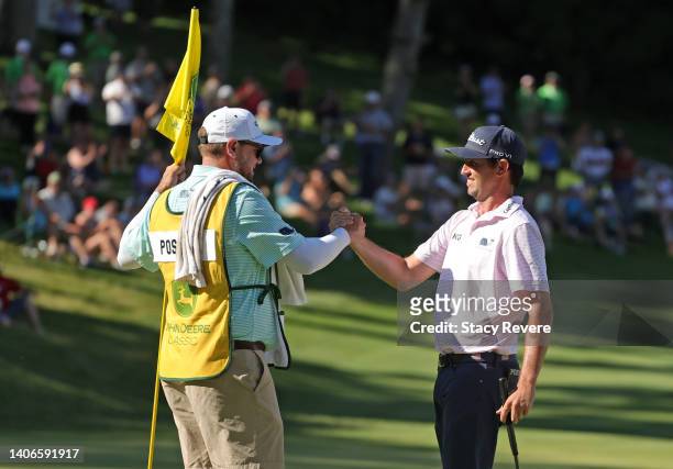Poston of the United States celebrates with his caddie Aaron Flener after putting in to win on the 18th green during the final round of the John...