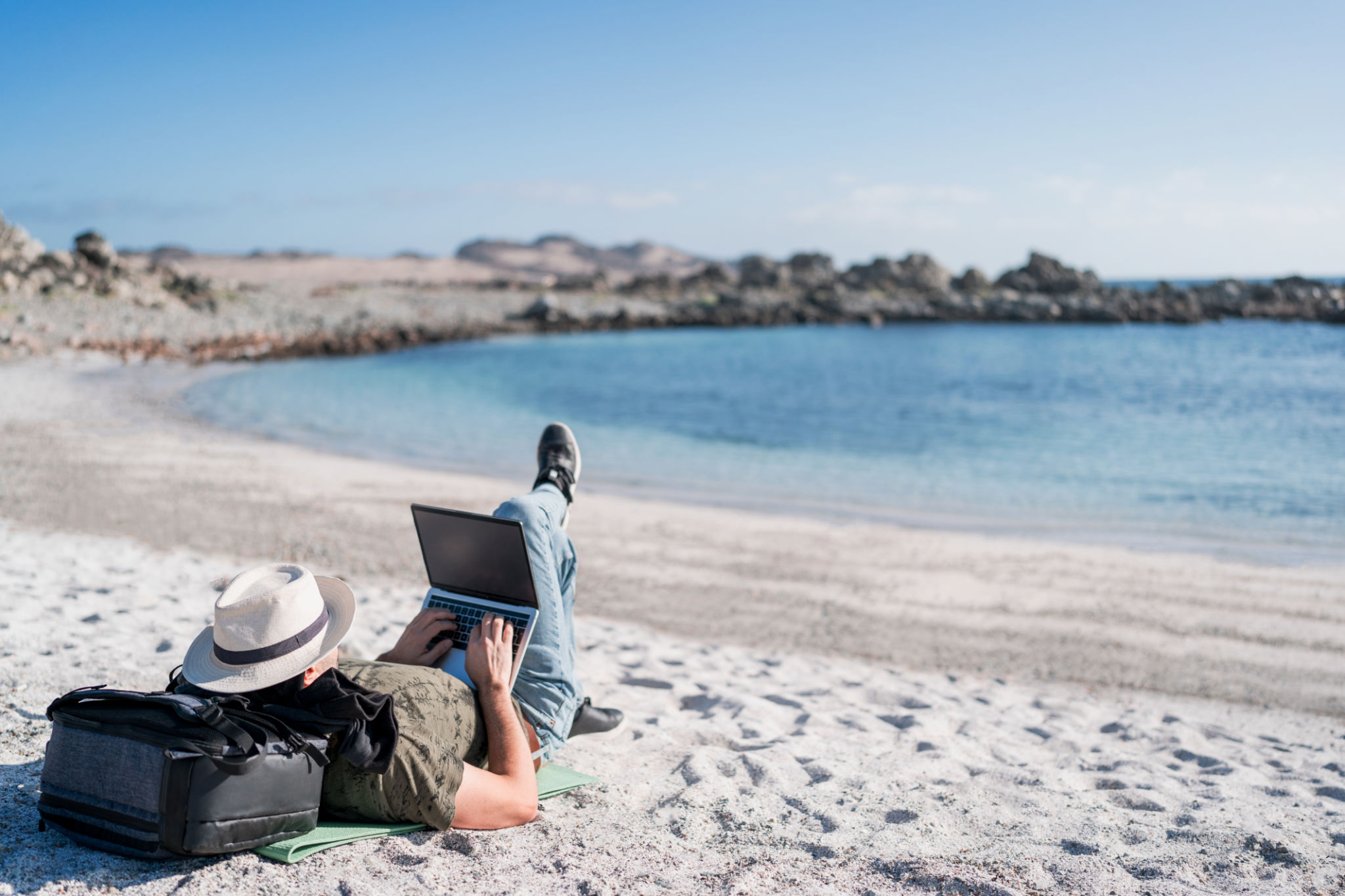 digital nomad lying on the beach outdoors alone working relaxed digital nomad lying on the beach outdoors alone working relaxed