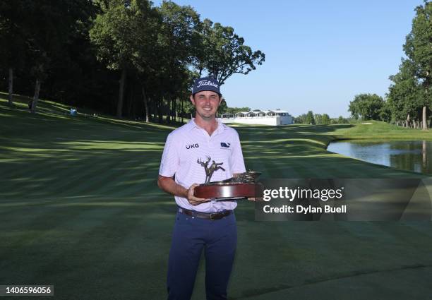 Poston of the United States poses with the trophy after putting in to win on the 18th green during the final round of the John Deere Classic at TPC...