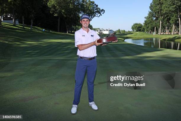 Poston of the United States poses with the trophy after putting in to win on the 18th green during the final round of the John Deere Classic at TPC...