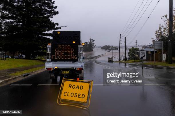 Sign indicating road closures due to flooding is seen at the Windsor Bridge along the Hawkesbury River in the suburb of Windsor, on July 04, 2022 in...