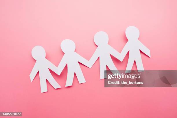 high angle view of paper people on pink background - human chain stockfoto's en -beelden