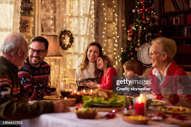cheerful extended family talking during christmas dinner at home. - kerstmis stockfoto's en -beelden