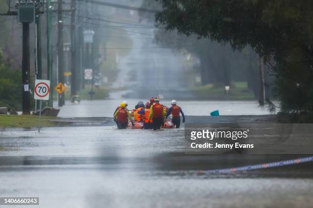 Family are evacuated by State Emergency Service workers due to rising floodwaters in Bligh Park on July 04, 2022 in Sydney, Australia. Thousands of...