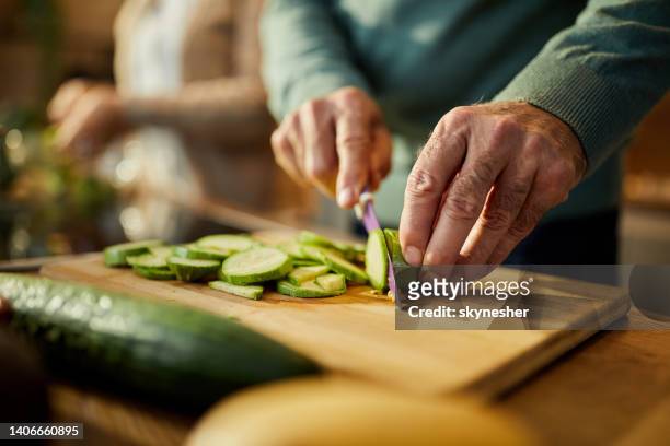 cutting fresh zucchini! - mature adult cooking stock pictures, royalty-free photos & images