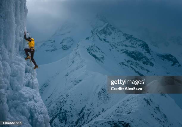 strong man climbing vertical ice wall - bearing stock pictures, royalty-free photos & images