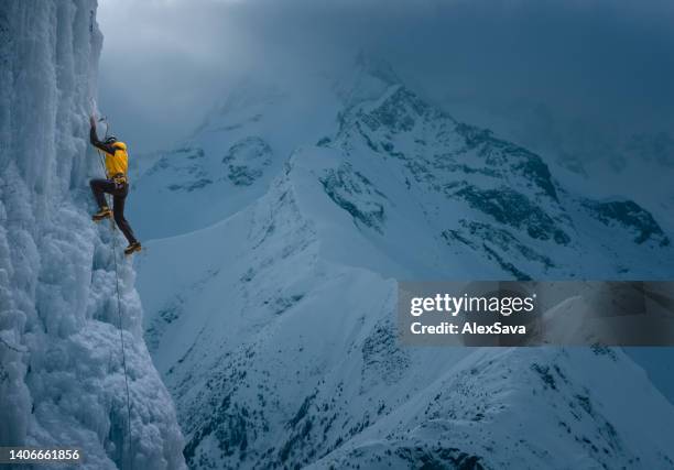 strong man climbing vertical ice wall - ice axe 個照片及圖片檔