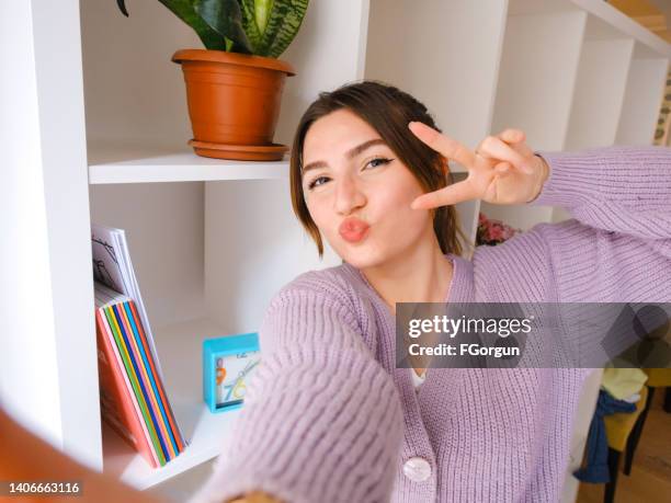 victory-sign-selfie eines jungen mädchens zu hause - one finger selfie stock-fotos und bilder