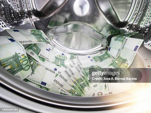 piles of 100 euro bills inside a washing machine. - money laundering 個照片及圖片檔