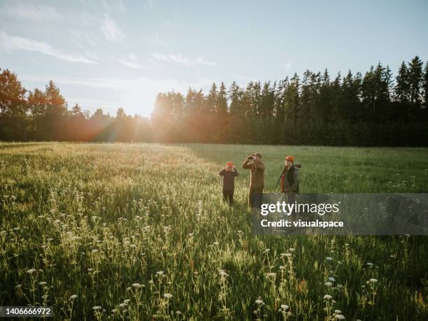 father teaching hunting to his sons - man watching fire stock pictures, royalty-free photos & images