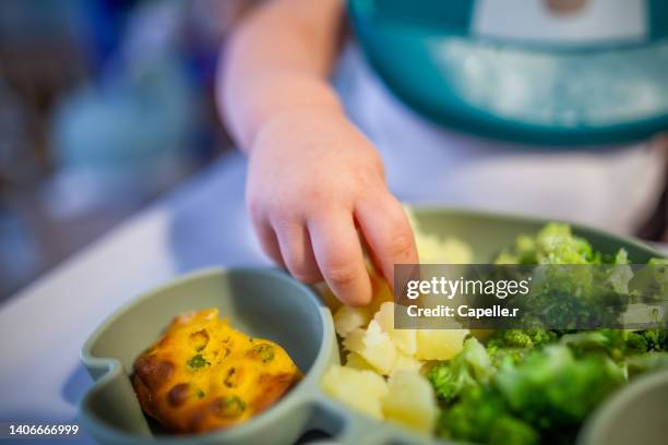 petite enfance - bébé mange avec les mains - petite enfance stock-fotos und bilder