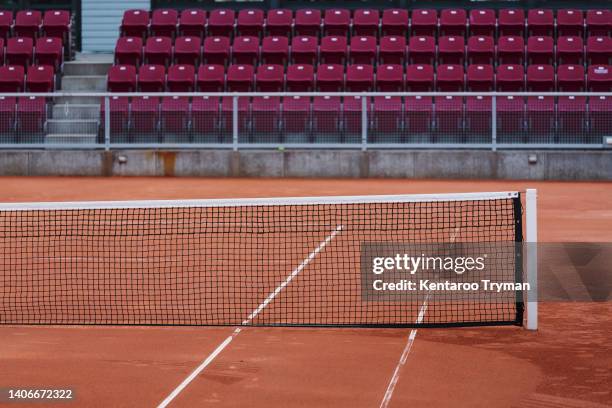 an empty tennis court with empty stands in the background - tennisnetz stock-fotos und bilder