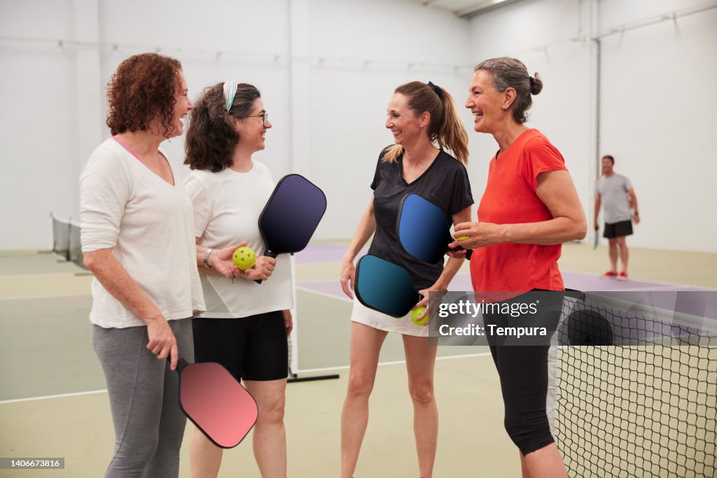 A group of friends chats after the pickleball game.