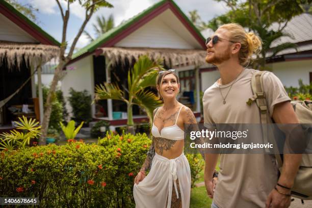 caucasian couple holding hands, while walking through tourist resort - thailand tourist stock pictures, royalty-free photos & images