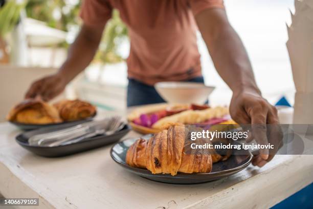 waiter serving croissants, american pancakes, and fruit plate at the restaurant - nutella pancake stock pictures, royalty-free photos & images