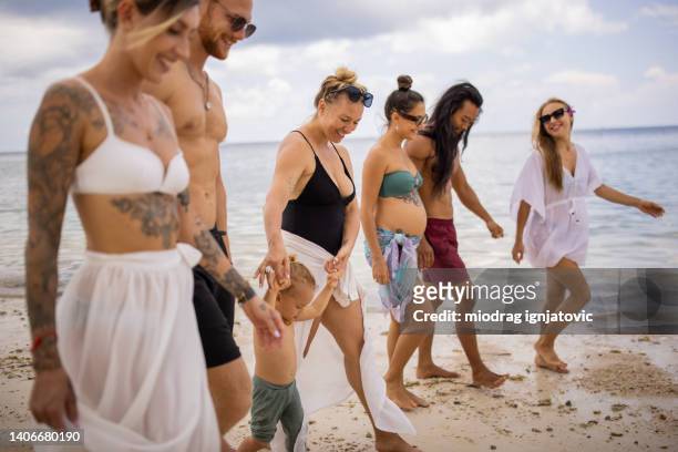 gruppo di amici multirazziali che camminano sulla spiaggia - asian man barefoot foto e immagini stock