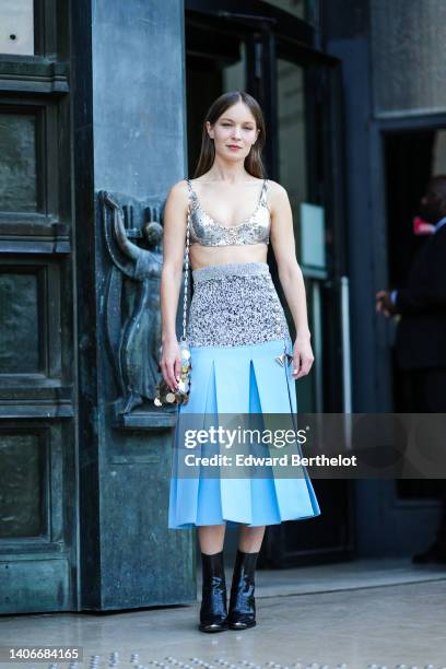 Diane Rouxel wears a silver sequined V-neck / cropped tank-top, a silver 1969 Nano metal-disc shoulder bag from Paco Rabanne, a high waist half gray...