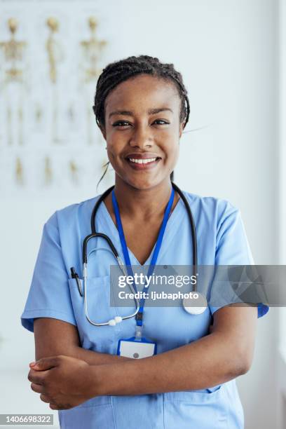 jovem enfermeira com braços cruzados em pé no hospital - nurse - fotografias e filmes do acervo