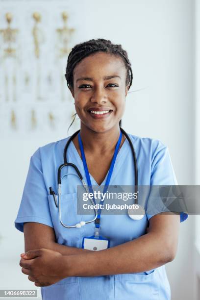 young female nurse with folded arms standing in hospital - black woman nurse bildbanksfoton och bilder