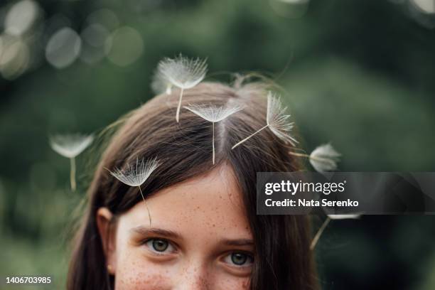 summer portrait of girl with big dandelion. happy child blowing dandelion outdoors in park - famiglia delle margherite foto e immagini stock