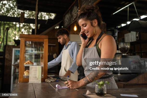 garçonete caucasiana falando no celular enquanto recebeva ordens - restaurant manager - fotografias e filmes do acervo