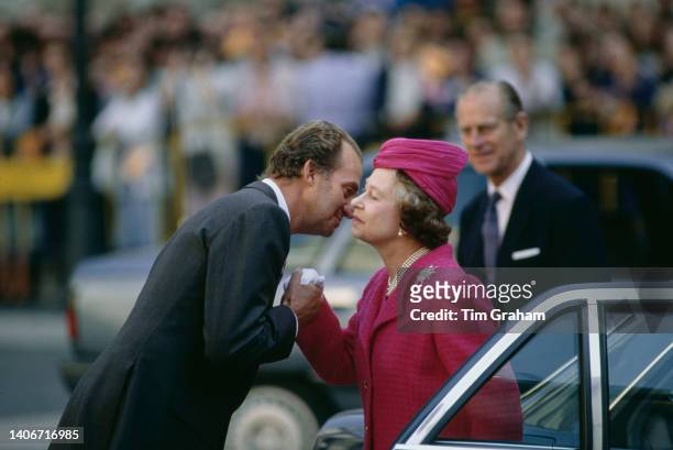 Queen Elizabeth II kisses goodbye to King Juan Carlos I as Prince Philip waits beside their car in Barcelona, Spain, 21st October 1988.