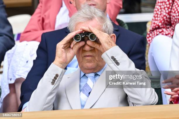 Sir Ian McKellen looks through a pair of binoculars during Day Eight of the Wimbledon Tennis Championships 2022 at All England Lawn Tennis and...