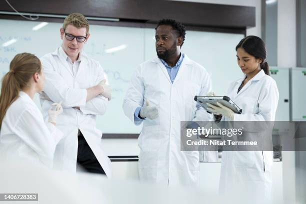 collaboration and team building of science in laboratory research. diversity of scientists or researcher is having a team meeting together of research result in microbiology laboratory. - genomics stock pictures, royalty-free photos & images