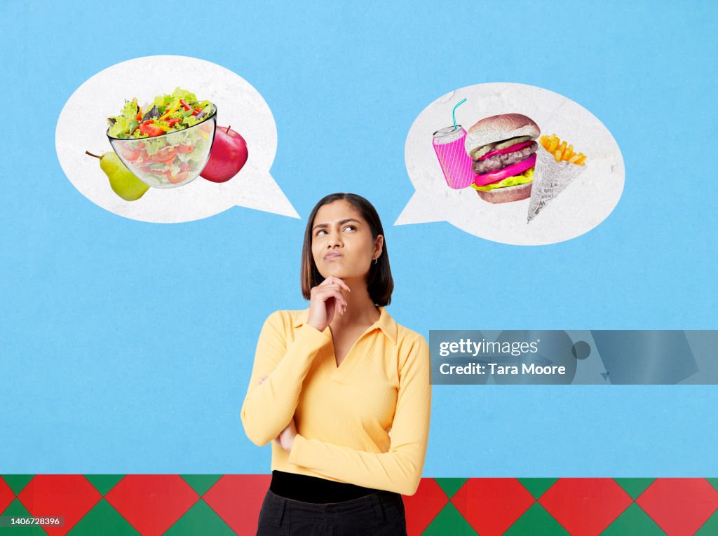 Woman choosing between healthy food and junk food