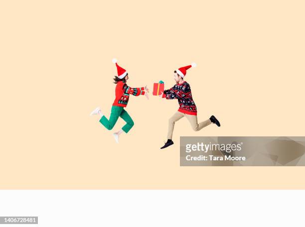 man and woman giving christmas present - 2022 a funny thing stock pictures, royalty-free photos & images