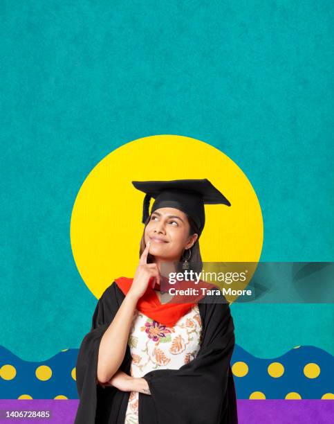 female  graduate looking up and smiling - college graduation ストックフォトと画像