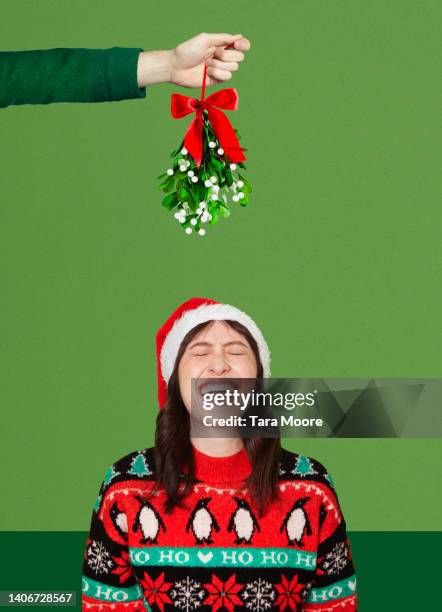 woman laughing under mistletoe - christmas montage stock pictures, royalty-free photos & images