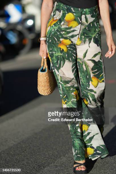 Guest wears a black asymmetric shoulder-off / sleeveless body, white denim with green leaves and yellow lemon print pattern wide legs pants, a beige...