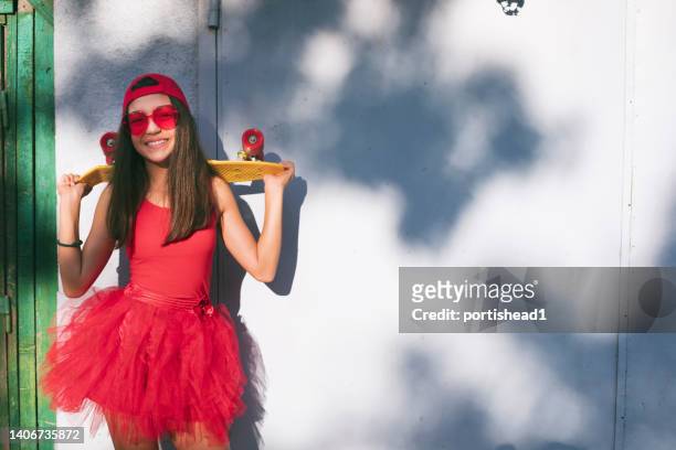 smiling girl with skateboard dressed in red - preteen model stock pictures, royalty-free photos & images