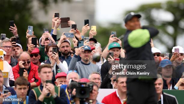 Spectators look on as Tiger Woods of United States plays his tee shot at the 1st hole during Day One of the JP McManus Pro-Am at Adare Manor on July...