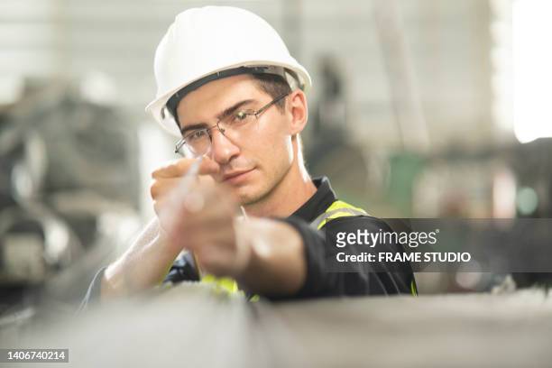 a male engineer is using an optical sight to measure the precision of the steel pipe used in the workpiece. for a kind of machine - electric fan bildbanksfoton och bilder