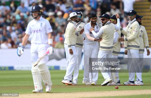 England batsman Ollie Pope leaves the crease as Jasprit Bumrah is congratulated by team mates after taking his wicket during day four of the Fifth...
