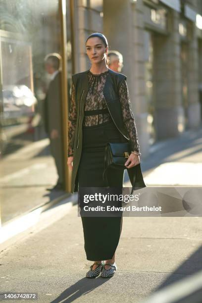 Guest wears a black lace print pattern high neck / long sleeves blouse, a black shiny leather zipper long jacket, black large pants, a black shiny...