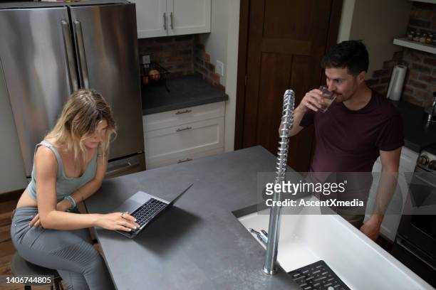 young man and woman share conversation in home kitchen setting - crop top stock pictures, royalty-free photos & images