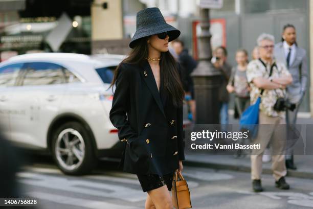 Guest poses wearing Schiaparelli jacket and a black straw hat before the Schiaparelli show at the Musee des Arts Decoratifs during Paris Fashion Week...