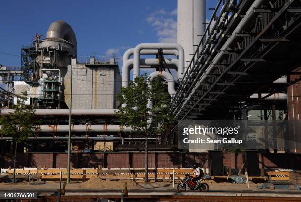 Man on a scooter rides past the Klingenberg natural gas-powered thermal power station on July 04, 2022 in Berlin, Germany. Germany still receives a...