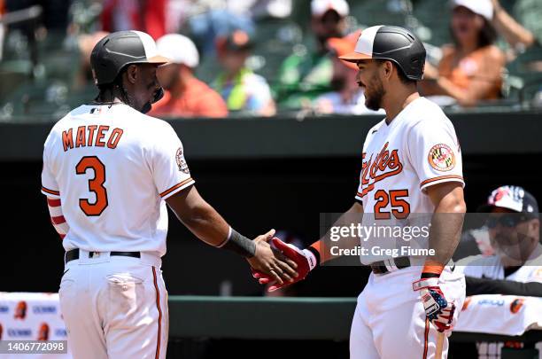 Jorge Mateo of the Baltimore Orioles celebrates with Anthony Santander after scoring in the third inning against the Texas Rangers at Oriole Park at...