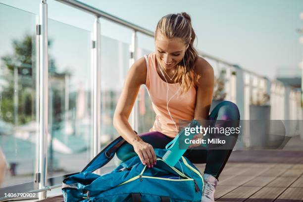 young woman preparing for her sports training - sporttas stockfoto's en -beelden