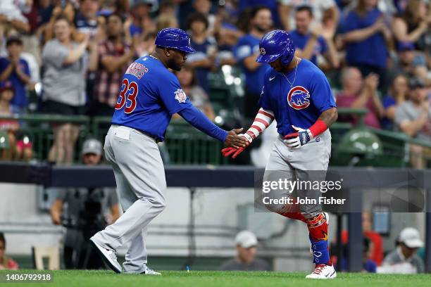 Nelson Velazquez of the Chicago Cubs is congratulated by third base coach Willie Harris of the Chicago Cubs after hitting a solo home run in the...