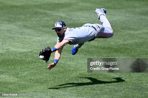 Steven Duggar of the Texas Rangers tries to catch a double hit by Rougned Odor of the Baltimore Orioles in the sixth inning at Oriole Park at Camden...