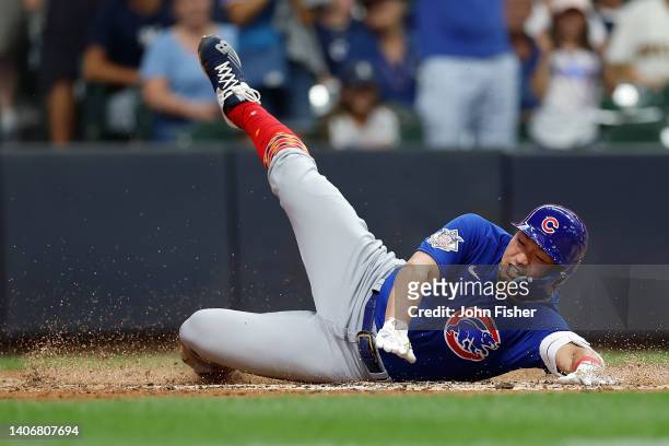 Seiya Suzuki of the Chicago Cubs slides across the plate with an inside-the-park home run in the ninth inning against the Milwaukee Brewers at...