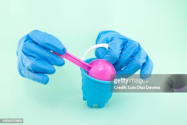 hands with blue gloves playing with sand toys - garden trowel stock pictures, royalty-free photos & images