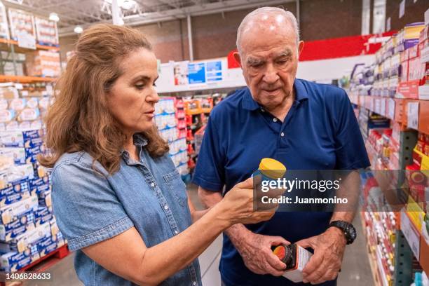 mature woman and a senior man shopping for over the counter medicines at a discount megastore - over 80 個照片及圖片檔