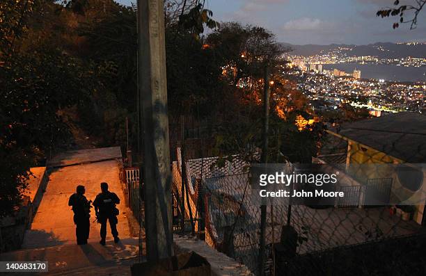 Mexican federal policemen stand guard at a suspected drug-related murder site March 3, 2012 in Acapulco, Mexico. A forensics team excavated five...